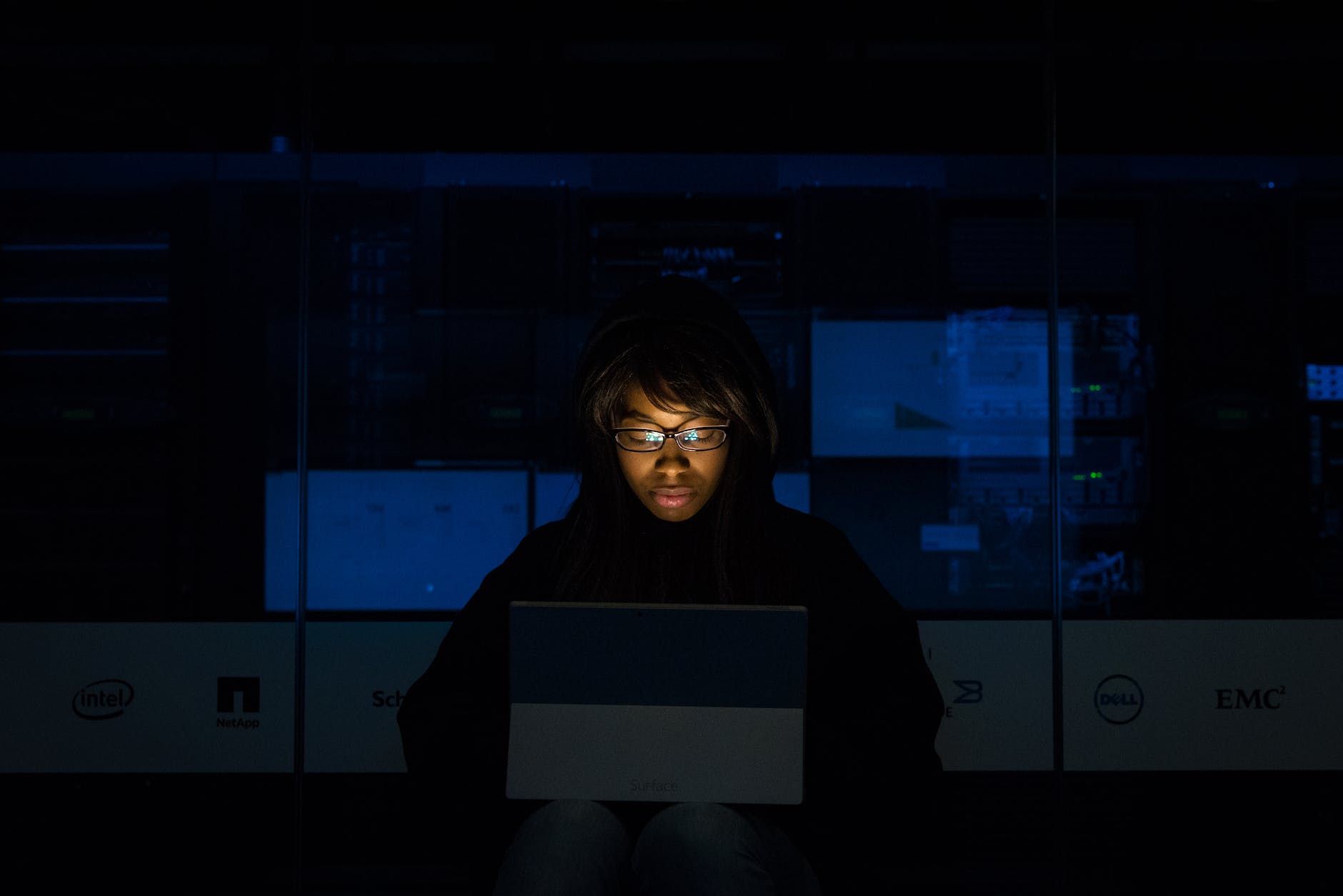 woman wearing black hoodie jacket holding grey laptop computer