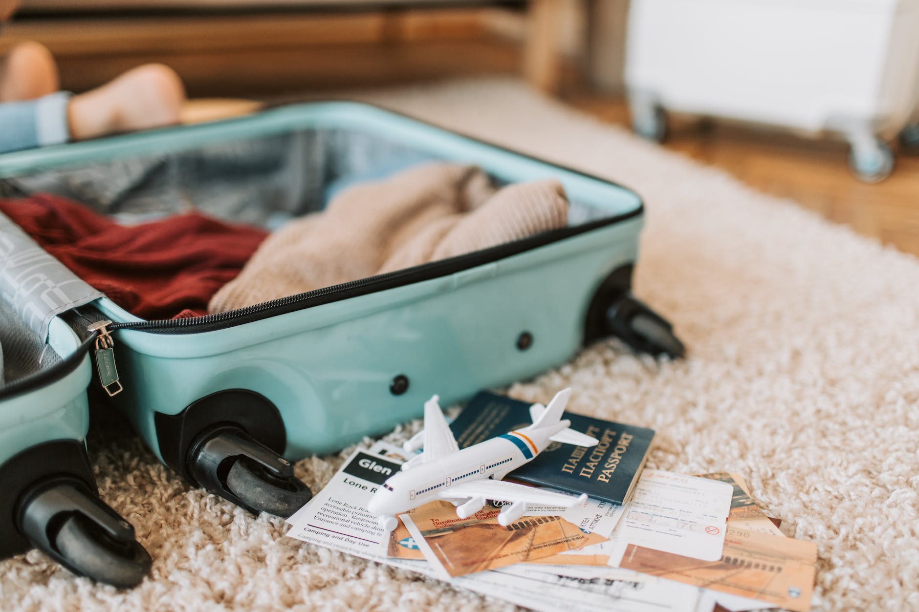 black and green luggage bag on brown carpet